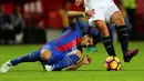 Penyerang Barcelona, Luis Suarez terjatuh saat berusaha merebut bola dari pemain Sevilla pada lanjutan La Liga spanyol di Stadion Sanchez Pizjuan,  Spanyol, (7/11). Barcelona menang atas Sevilla 2-1. (REUTERS/ Marcelo del Pozo)