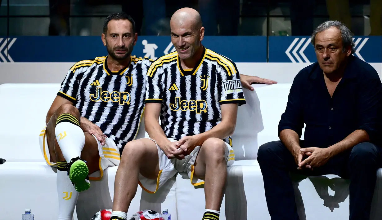Mantan pemain Juventus (dari kiri) Mark Juliano, Zinedine Zidane dan Michel Platini duduk di bangku cadangan Tim Putih dalam laga persabatan mini soccer 7 lawan 7 di Pala Alpitour, Turin, Rabu (11/10/2023) dini hari WIB yang diikuti para legenda Juventus dalam rangkaian perayaan 100 tahun Keluarga Agnelli mengakuisisi Juventus. Hasil laga dimenangkan Tim Putih 9-6 atas Tim Hitam. (AFP/Marco Bertorello)