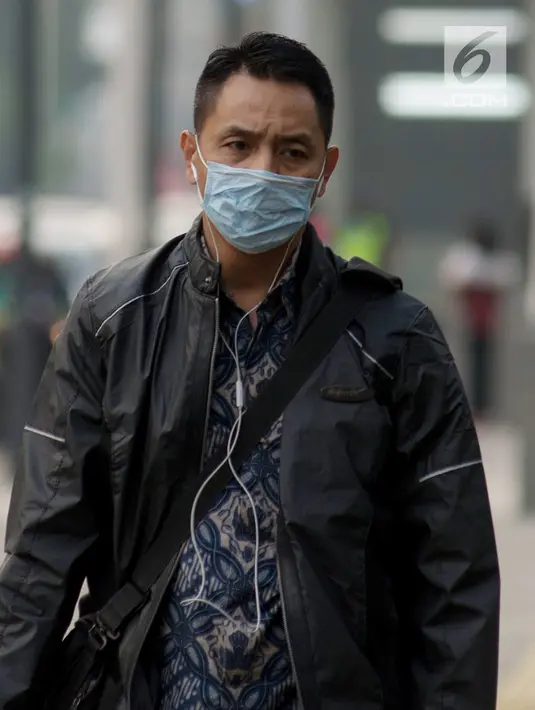 Pejalan kaki mengenakan masker saat berjalan di Jakarta, Kamis (4/7/2019). Organisasi lingkungan Greenpeace menyatakan kualitas udara Jakarta saat ini terpantau sangat tidak sehat dengan angka 165 AQI atau Indeks Kualitas Udara. (merdeka.com/Imam Buhori)