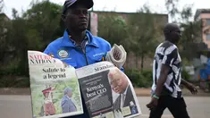 Seorang penjual menjajakan koran lokal dengan penghormatan untuk mantan presiden Kenya Mwai Kibaki, di Nairobi, pada 23 April 2022. Mantan Presiden Kenya, Mwai Kibaki, yang pernah memimpin negara Afrika Timur itu selama lebih dari satu dekade, dikabarkan meninggal dunia pada Jumat (22/4) di usia 90 tahun. (Simon MAINA / AFP)