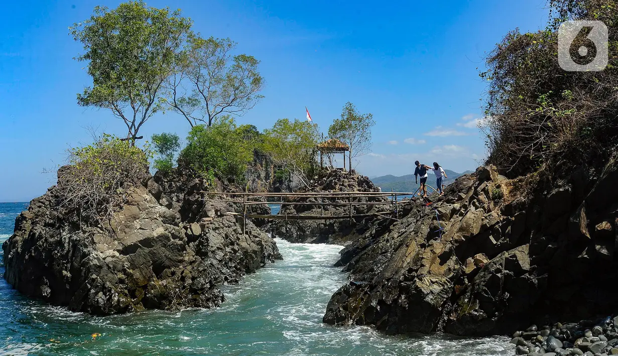 Warga asal Lamongan berjalan menikmati keindahan Lembah Watu Pawon di Desa Wisata Nglebeng, Kecamatan Panggul, Trenggalek, Jumat (01/09/2023). (merdeka.com/Arie Basuki)