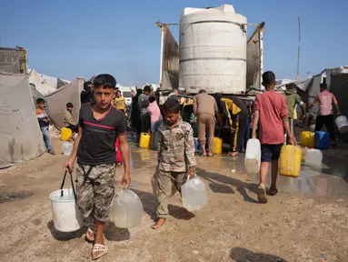 Para pengungsi Palestina berkumpul untuk mengambil air dari sebuah truk di kamp tenda darurat, Khan Younis, Jalur Gaza Selatan, Kamis 30 April 2026. Pengungsi Palestina di kamp-kamp pengungsian darurat di Khan Younis, Jalur Gaza Selatan masih menghadapi krisis air bersih yang parah. (AP Photo/Abdel Kareem Hana)