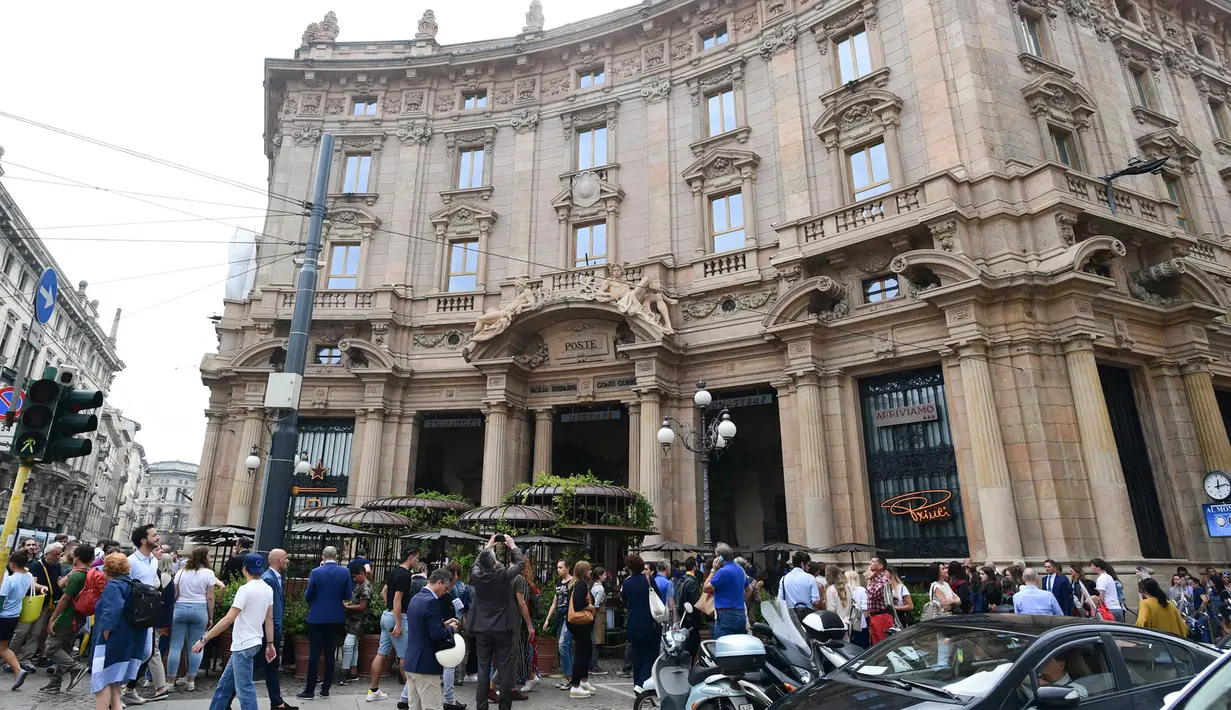 Orang-orang mengambil gambar gerai pertama Starbucks di Milan, Italia, Jumat (7/9). Mungkin karena lokasinya berada di pusat keramaian kota Milan, harga setiap menu di cafe ini sedikit berbeda dari cafe – cafe Italia lainnya. (Miguel MEDINA / AFP)