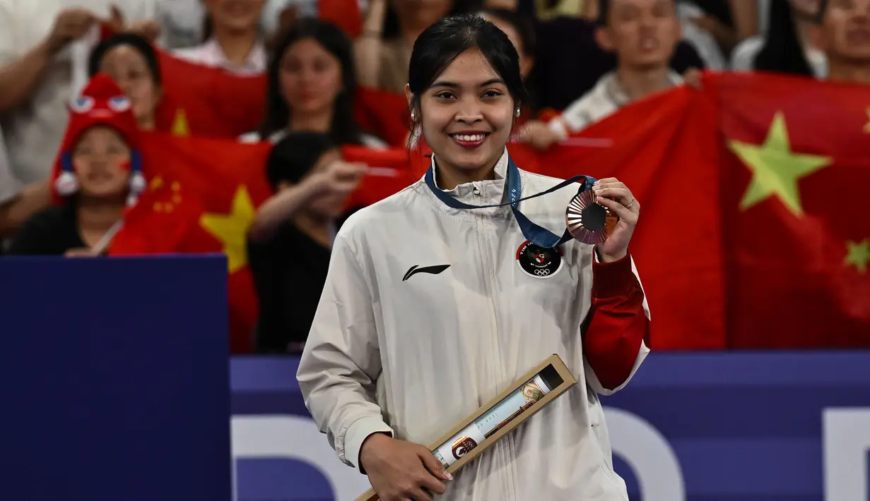 Pebulu tangkis Indonesia, Gregoria Mariska Tunjung berpose di atas podium dengan medali perunggu nomor tunggal putri cabor bulu tangkis Olimpiade Paris 2024 saat upacara penyerahan medali di Porte de La Chapelle Arena, Paris, Senin (5/8/2024). (Dok. NOC Indonesia/Antara/Wahyu Putro A)