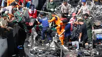 Tim SAR gabungan mengevakuasi jenazah dari atas kapal Zahro Express yang terbakar, di Pelabuhan Muara Angke, Jakarta, Minggu (1/1). Kebakaran kapal penumpang di perairan Pulau Untung Jawa itu diduga berawal dari mesin kapal. (REUTERS/Darren Whiteside)