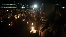 Seorang wanita ikut bergabung menyalakan lilin dalam aksi dukungan pada komunitas muslim di Toronto, Senin (30/1). Dukungan itu setelah aksi penembakan di sebuah masjid di Kota Quebec, Kanada yang menewaskan 6 orang (Chris Young/The Canadian Press via AP)