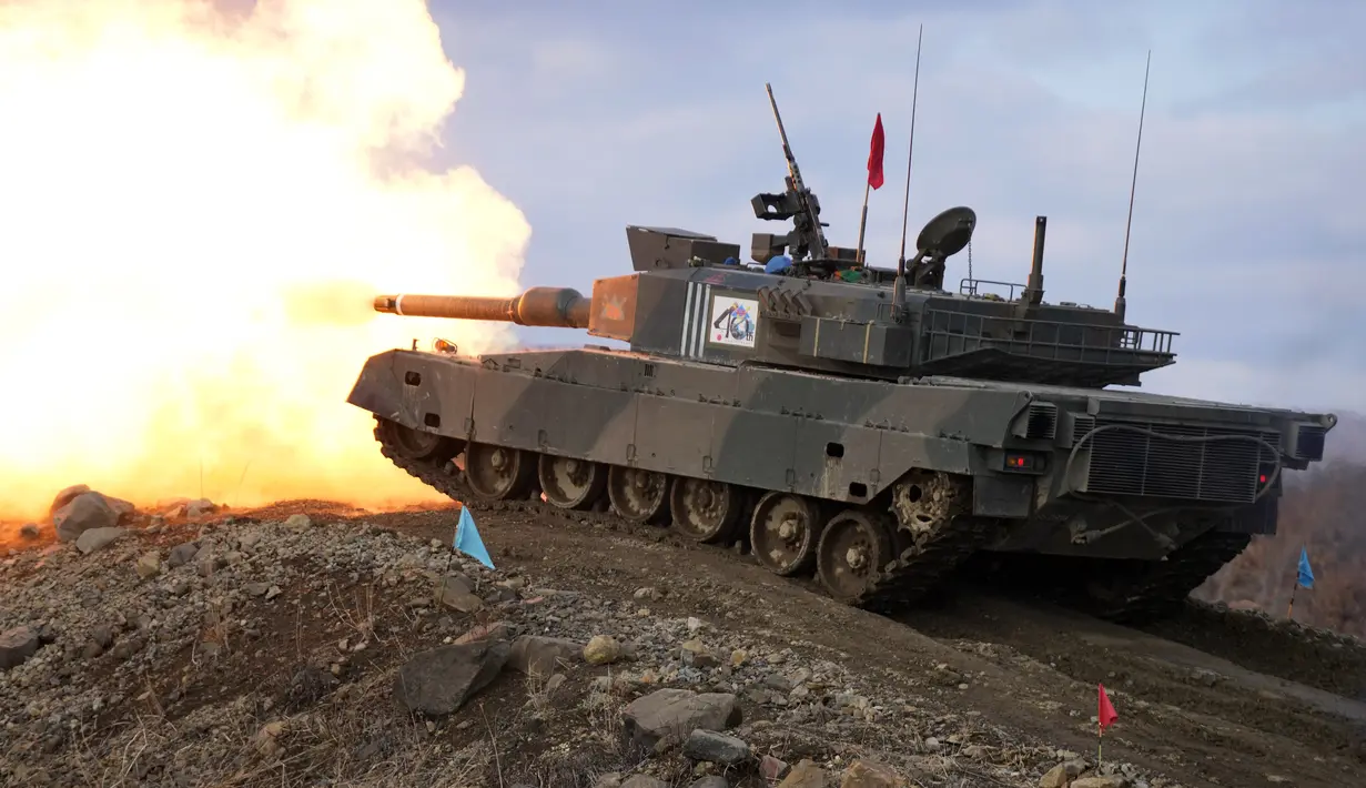 Tank Angkatan Darat Bela Diri Jepang Type 90 menembakkan senjatanya ke sasaran saat latihan tahunan dengan peluru tajam di Minami Eniwa Camp, Eniwa, Pulau Hokkaido, Jepang, 6 Desember 2021. Jepang terus membangun kekuatan militer. (AP Photo/Eugene Hoshiko)