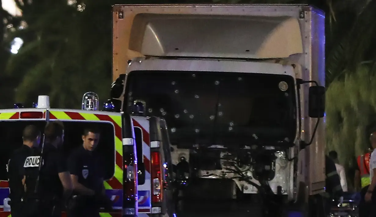 Kondisi sebuah truk putih yang menabrak kerumunan orang yang tengah menyaksikan festival di Nice, Prancis, Kamis (14/7). Hingga kini belum jelas siapa identitas pelaku dan apa motif di balik serangan tersebut. (VALERY HACHE/AFP)