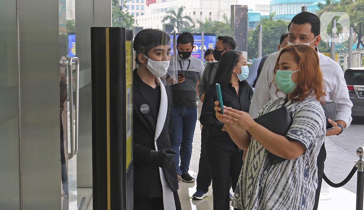 Pengunjung melakukan scan kode QR untuk memasuki Mall Senayan City, Jakarta, Senin (15/6/2020). Pusat perbelanjaan atau mal di Jakarta kembali dibuka pada Senin (15/6) di masa PSBB transisi dengan jumlah pengunjung masih dibatasi hanya 50 persen dari kapasitas normal. (Liputan6.com/Herman Zakharia)