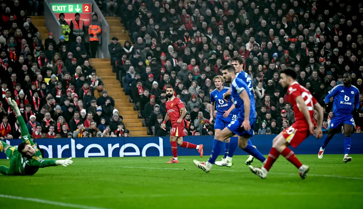 Pelatih Liverpool, Mohamed Salah mencetak gol ketiga timnya ke gawang Leicester dalam laga lanjutan Liga Inggris 2024/2025 di Anfield, Liverpool, Inggris, Jumat (27/12/2024) WIB. (AFP/Paul Ellis)