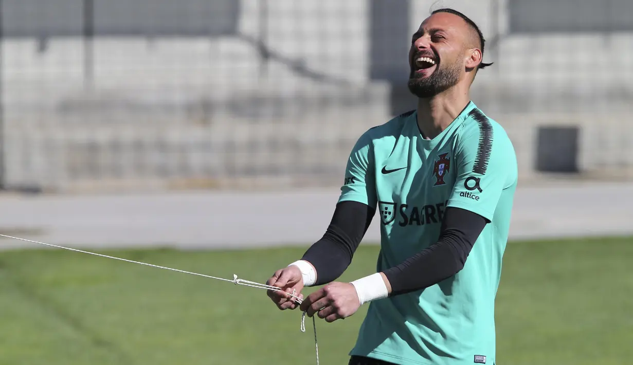 Kiper Portugal, Beto, tertawa saat latihan jelang laga kualifikasi Piala Eropa di Lisbon, Selasa (19/3). Portugal akan berhadapan dengan Ukraina. (AP/Armando Franca)
