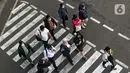 Sejumlah pekerja menyeberang jalan saat jam pulang kerja di kawasan Thamrin, Jakarta, Selasa (11/7/2023). Pemerintah Provinsi (Pemprov) DKI Jakarta menyebut penerapan pengaturan jam masuk kerja bagi perusahaan swasta di DKI Jakarta hanya bersifat imbauan. (Liputan6.com/Angga Yuniar)