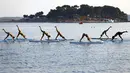 Sejumlah wanita berbikini ketika berlatih yoga Float Metta dengan papan seluncur di Laut Adriatic, Kroasia, Kamis (6/8/2015). (REUTERS/Pawel Kopczynski)