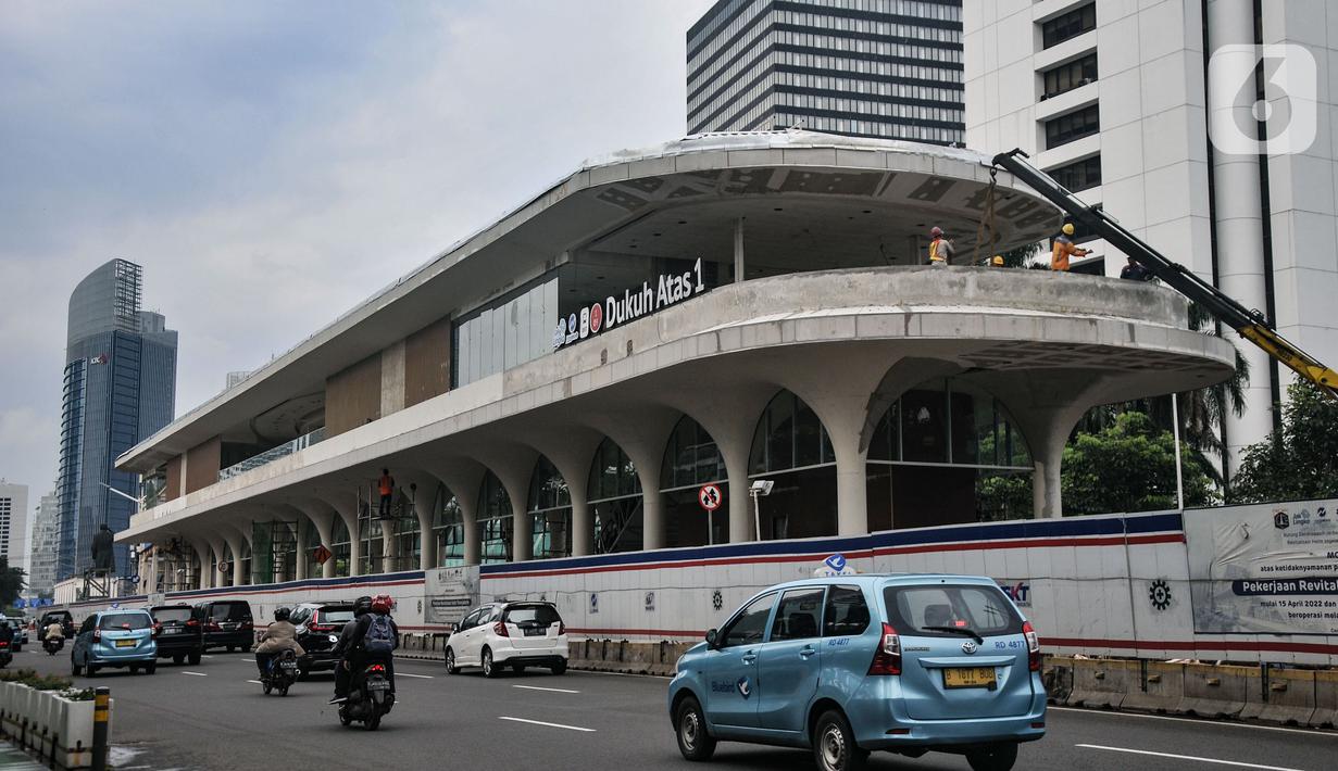Pengendara melintasi proyek pembangunan halte Transjakarta Dukuh Atas 1 di Jalan Jenderal Sudirman, Jakarta Pusat, Kamis (5/1/2023). Direktur Teknik dan Digital Transjakarta Mohamad Indrayana mengungkapkan pada 2023 PT TransJakarta menargetkan dapat menyelesaikan 54 halte yang sudah siap beroperasi untuk kepentingan mobilitas warga. (merdeka.com/Iqbal S Nugroho)