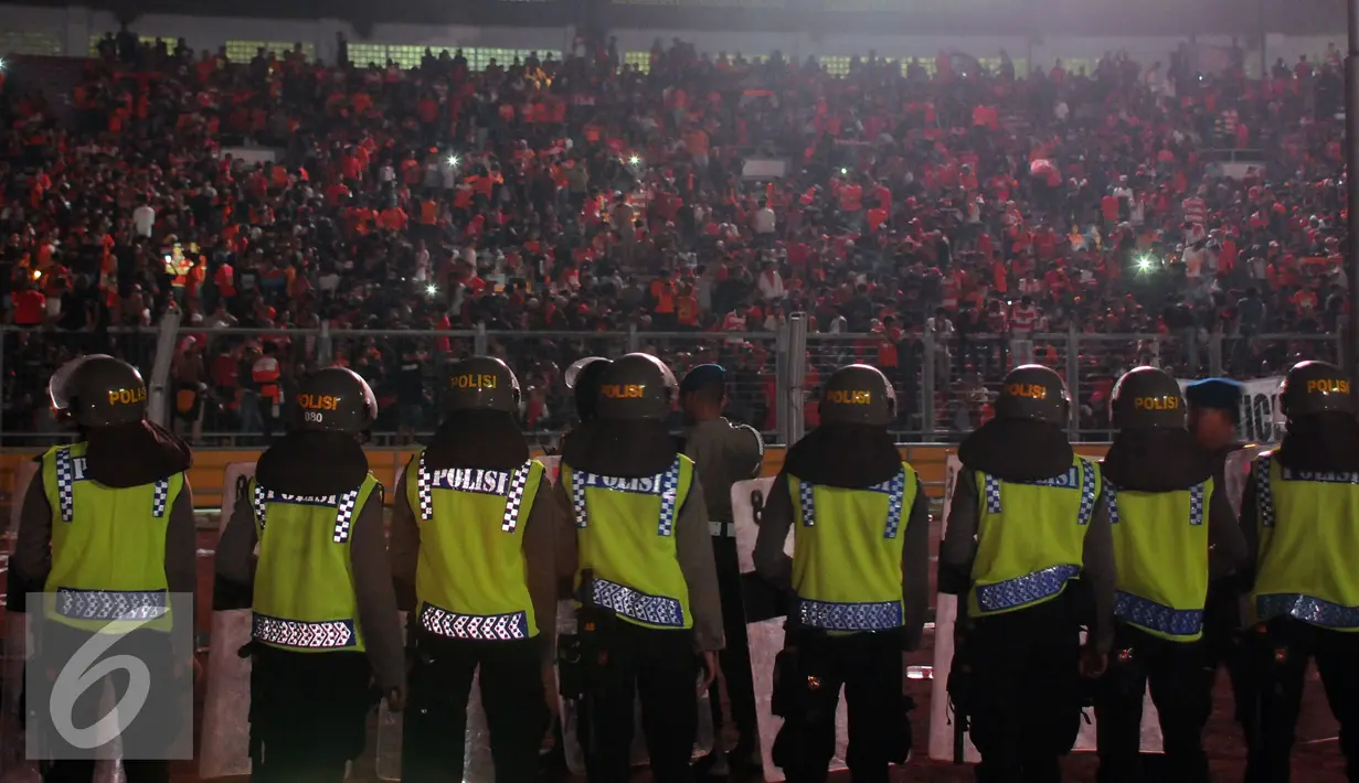 Aparat kepolisian berjaga di pinggir lapangan saat laga Persija melawan PS TNI di Stadion GBK Jakarta, Jumat (10/6). Ribuan suporter Persija melakukan aksi meminta pengungkapan kasus tewasnyaM Fahreza (13/5) lalu. (Liputan6.com/Helmi Fithriansyah)