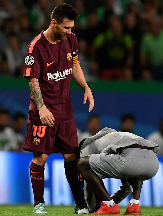 Suporter memeluk penyerang Barcelona, Lionel Messi saat pertandingan grup D Liga Champions melawan Sporting CP di stadion Alvalade, Lisbon, (27/9). Sepanjang berkarier di level klub Messi telah membuat 317 gol dari kakinya. (AFP Photo/Francisco Leong)