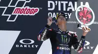 Pembalap Yamaha Fabio Quartararo melihat dan menunjuk ke langit selama upacara podium pada akhir Motogp Mugello di Sirkuit Mugello, Scarperia, Italia, Minggu (30/5/2021). Fabio Quartararo berhasil meraih posisi pertama. (AP Photo/Antonio Calanni)