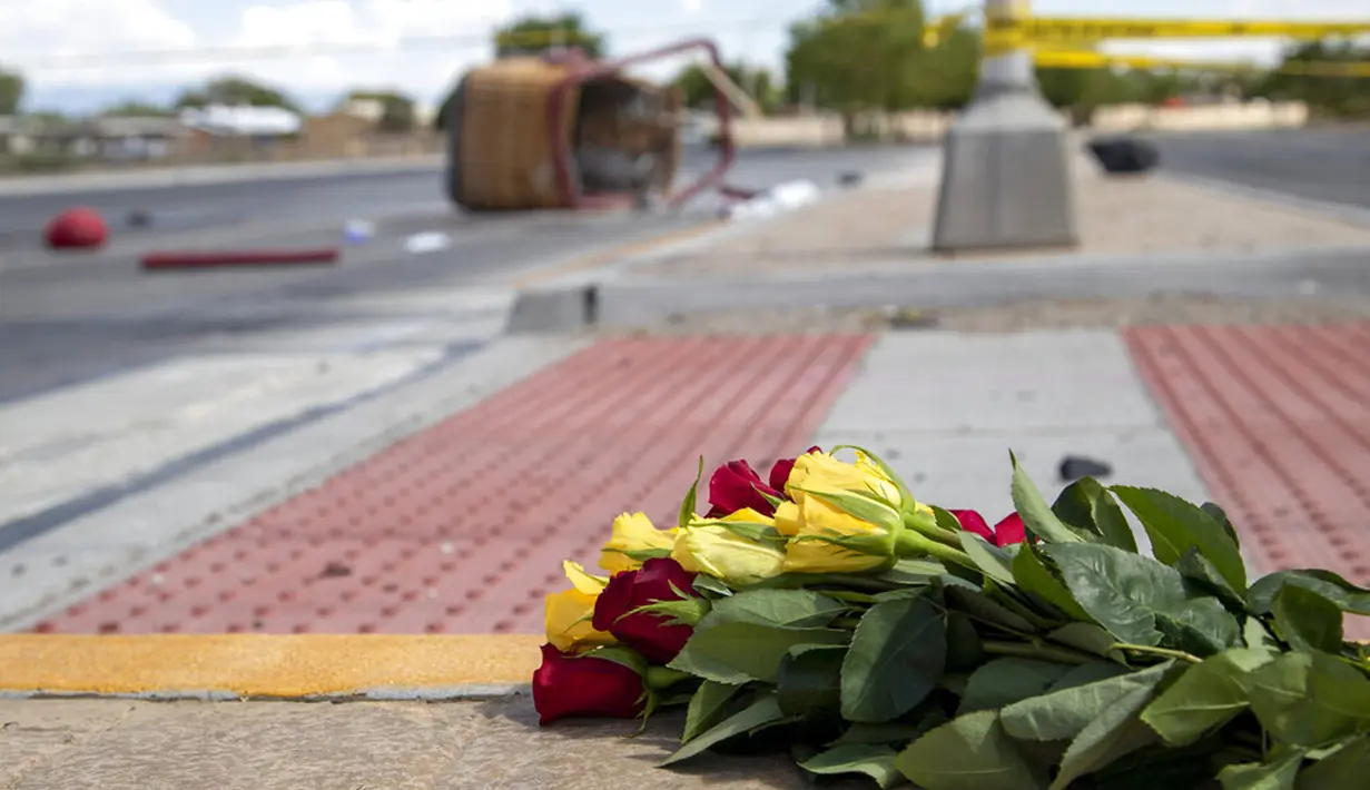 Buket bunga dari pelayat ditempatkan dekat keranjang balon udara yang jatuh di Albuquerque, New Mexico, Amerika Serikat, Sabtu (26/6/2021). Balon itu melayang sebelum mendarat di tempat lain. (AP Photo/Andres Leighton)