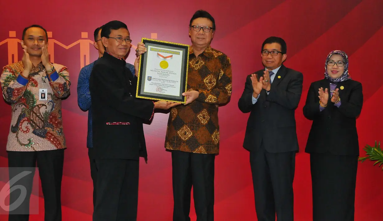 Mendagri Tjahjo Kumolo menerima piagam rekor MURI usai melakukan penandatangan kerja sama pemanfaatan data kependudukan dengan 100 pelaku usaha Bursa Efek Indonesia (BEI) di Gedung BEI, Jakarta, Selasa (22/11). (Liputan6.com/Angga Yuniar)