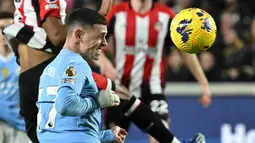 Pemain Manchester City, Phil Foden, mencetak gol melalui tandukan kepala ke gawang Brentford pada laga Liga Inggris di Stadion Gtech Community, Selasa (6/2/2024). Foden memborong tiga gol. (AFP/Ben Stansall)