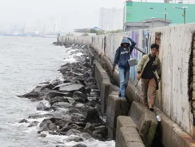 Warga sedang memancing di tanggul laut kawasan Muara Baru, Jakarta, Selasa (4/2/2025). (Liputan6.com/Herman Zakharia)