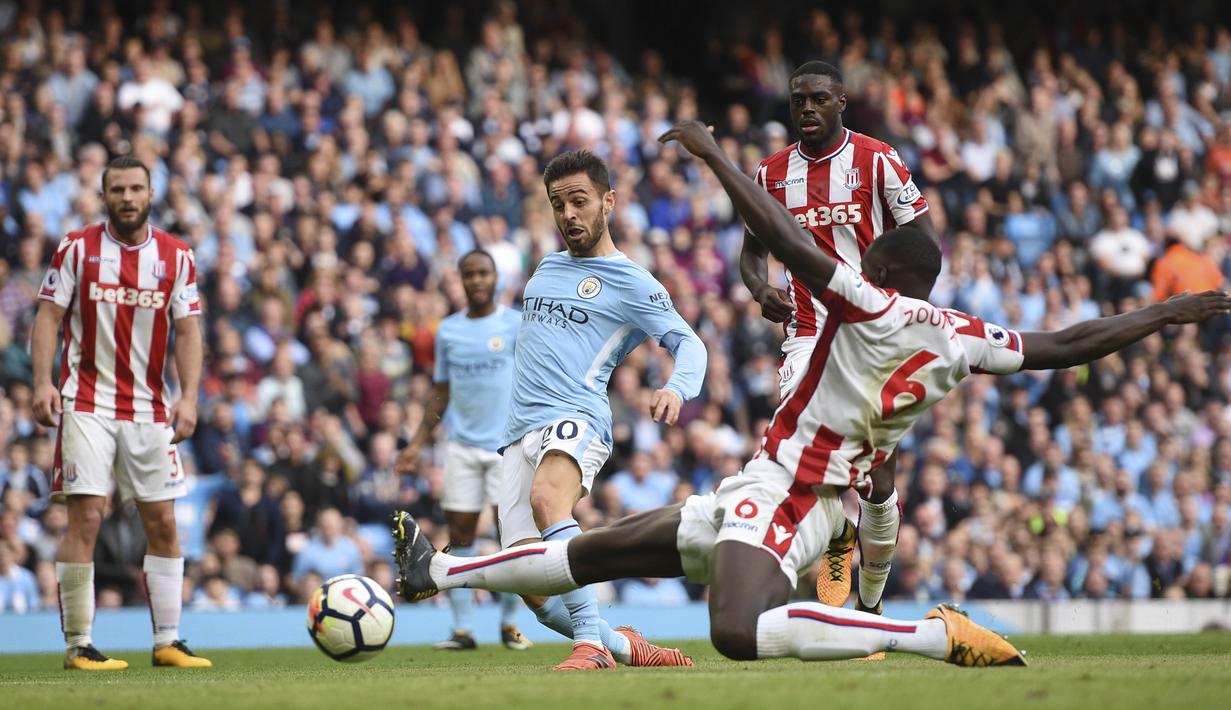 Bernardo Silva (tengah) menambah keunggulan timnya dengan satu gol pada menit akhir ke gawang Stoke City pada laga Premier League di Etihad Stadium, Manchester, (14/10/2017). Manchester City menang telak 7-2. (AFP/Oli Scarff)
