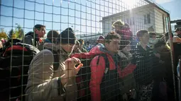 Ribuan imigran bersama bayinya berdesakan di Sentilj, Slovenia untuk memasuki Austria, Selasa (3/11). Slovenia mengatakan kewalahan menghadapi arus ribuan migran yang melintasi wilayah negara itu untuk menuju Eropa barat. (AFP PHOTO/RENE GOMOLJ)