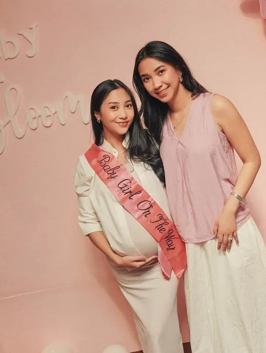Tampilannya pun ditambah dengan sash pink dengan tulisan Baby Girl On The Way. Melengkapi tampilannya dengan anting-anting hoop minimalis. Rambutnya ditata panjang wavy belah dua. Dengan riasan naturalnya. [@nonawilly]