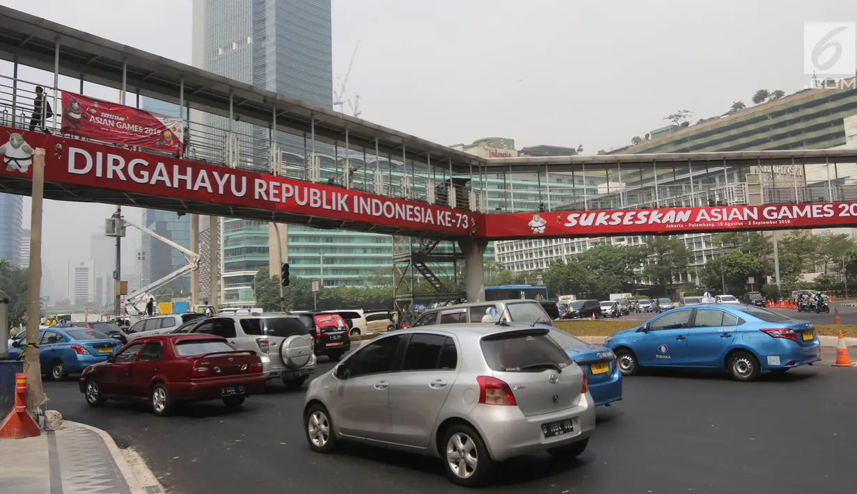Pengendara melintas melintas di bawah jembatan penyeberangan orang (JPO) di Bundaran HI, Jakarta, Selasa (24/7). Pemprov DKI berencana merobohkan JPO tersebut karena menghalangi pandangan ke Patung Selamat Datang. (Liputan6.com/Arya Manggala)