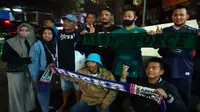Seorang bonek Persebaya Surabaya berpose bersama rekan-rekannya dari Aremania usai peringatan tujuh hari tragedi Stadion Kanjuruhan Malang yang digelar pada Jumat, 7 Oktober 2022. Peristiwa pilu itu diharapkan jadi pintu perdamaian bagi seluruh kelompok suporter di Indonesia (Liputan6.com/Zainul Arifin)