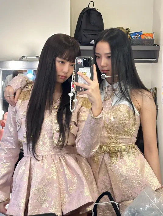 Jennie (kiri) dan Jisoo (kanan) saat mirror selfie di belakang panggung. Gaya rambut keduanya berbanding terbalik, Jennie yang menutup jidatnya dengan poni barunya, sedangkan Jisoo membiarkan jidatnya tanpa poni. (Instagram/@jennierubyjane)