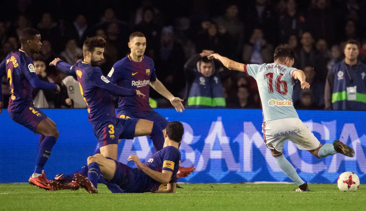 Pemain Barcelona mengamati pemain Celta Vigo, Jozabed melakukan tendangan pada pertandingan leg pertama babak 16 besar Copa del Rey di Stadion Balaidos, Kamis (4/1). Barcelona dan Celta Vigo mengakhiri laga dengan skor imbang 1-1. (AP/Lalo R. Villar)