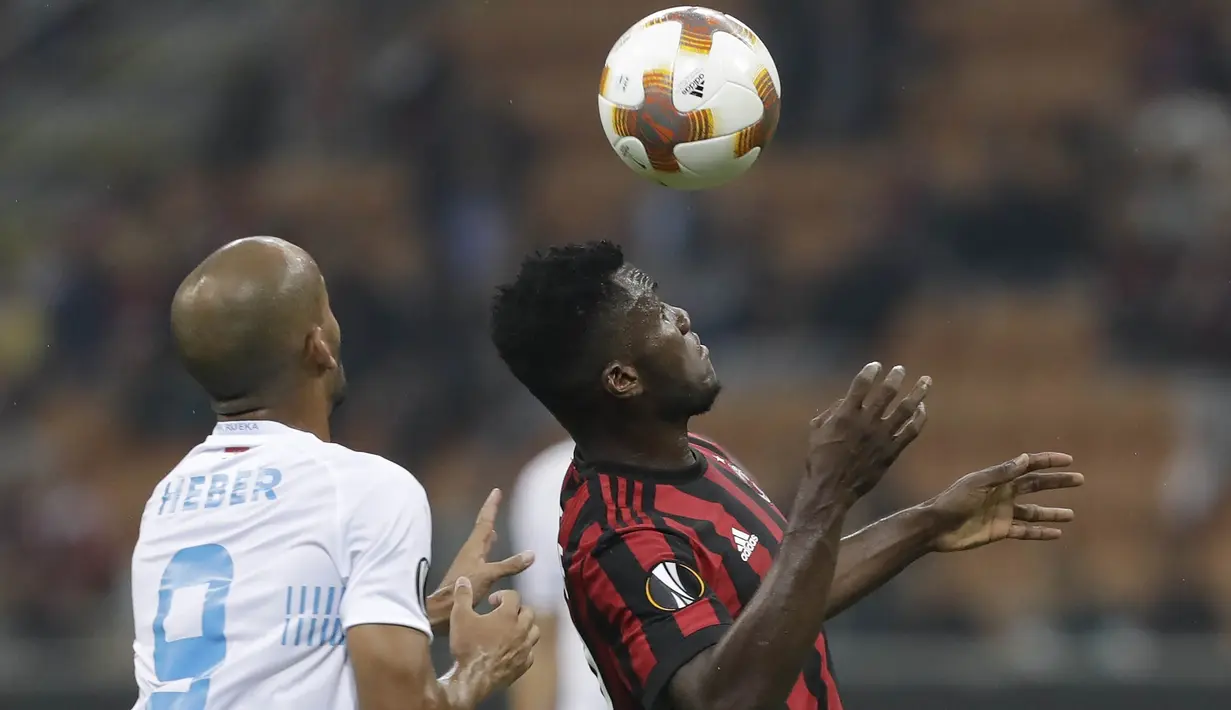 Gelandang AC Milan, Franck Kessie, duel udara dengan  gelandang Rijeka, Heber, pada laga Liga Europa di Stadion San Siro, Milan, Kamis (28/9/2017). AC Milan menang 3-2 atas  Rijeka. (AP/Luca Bruno)