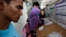 Seorang calon penumpang kereta api tampak melihat contoh formulir pemesanan kereta dengan seksama, Stasiun Senen, Jakarta, Senin (28/4/2014) (Liputan6.com/Faizal Fanani).