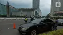 Polisi mengimbau pengguna jalan yang menggunakan kendaraan pribadi mobil dan motor yang berboncengan di Bundaran HI, Jakarta, Jumat (10/4/2020). Penerapan hari pertama PSBB hingga 14 hari kedepan ini dilakukan untuk mencegah penyebaran COVID-19 dan selalu menggunakan masker.(merdeka.com/Imam Buhori)