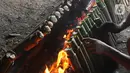 Pekerja membakar lemang di kawasan Kwitang, Jakarta, Minggu (9/3/2025). (Liputan6.com/Herman Zakharia)