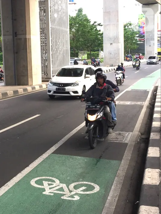 Pengendara sepeda motor melintasi jalur khusus sepeda di Jalan Fatmawati Raya, Jakarta, Rabu (22/1/2020). Kurangnya penerapan sanksi menyebabkan jalur khusus bagi pesepeda tersebut tidak steril dari kendaraan bermotor. (Liputan6.com/Immanuel Antonius)