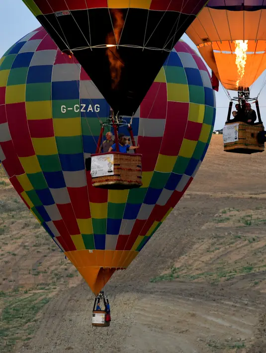 Sejumlah balon udara terbang dalam festival internasional Sagrantino di kawasan Umbria, Italia, 22 Juli 2018. Puluhan balon udara saling berkompetisi menghadapi tantangan dalam festival yang memperebutkan piala perak tersebut. (AFP PHOTO/TIZIANA FABI)