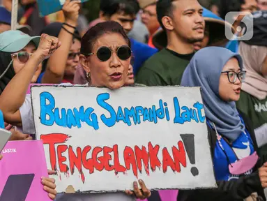 Mantan Menteri Kelautan dan Perikanan Susi Pudjiastuti membawa poster saat mengikuti pawai bebas plastik di kawasan Sudirman, Jakarta, Minggu (30/7/2023). (Liputan6.com/Faizal Fanani)