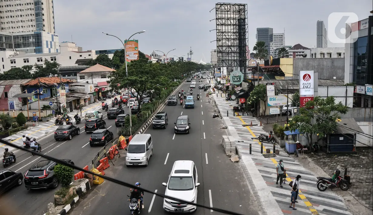 Lalu lintas kendaraan melintas di tengah penyelesaian proyek revitalisasi trotoar di Jalan Margonda Raya, Depok, Jawa Barat, Minggu (4/12/2022). Pemerintah Kota Depok lewat Dinas Pekerjaan Umum dan Penataan Ruang (DPUPR) menganggarkan Rp23,5 miliar untuk revitalisasi trotoar di Jalan Margonda. (merdeka.com/Iqbal S Nugroho)