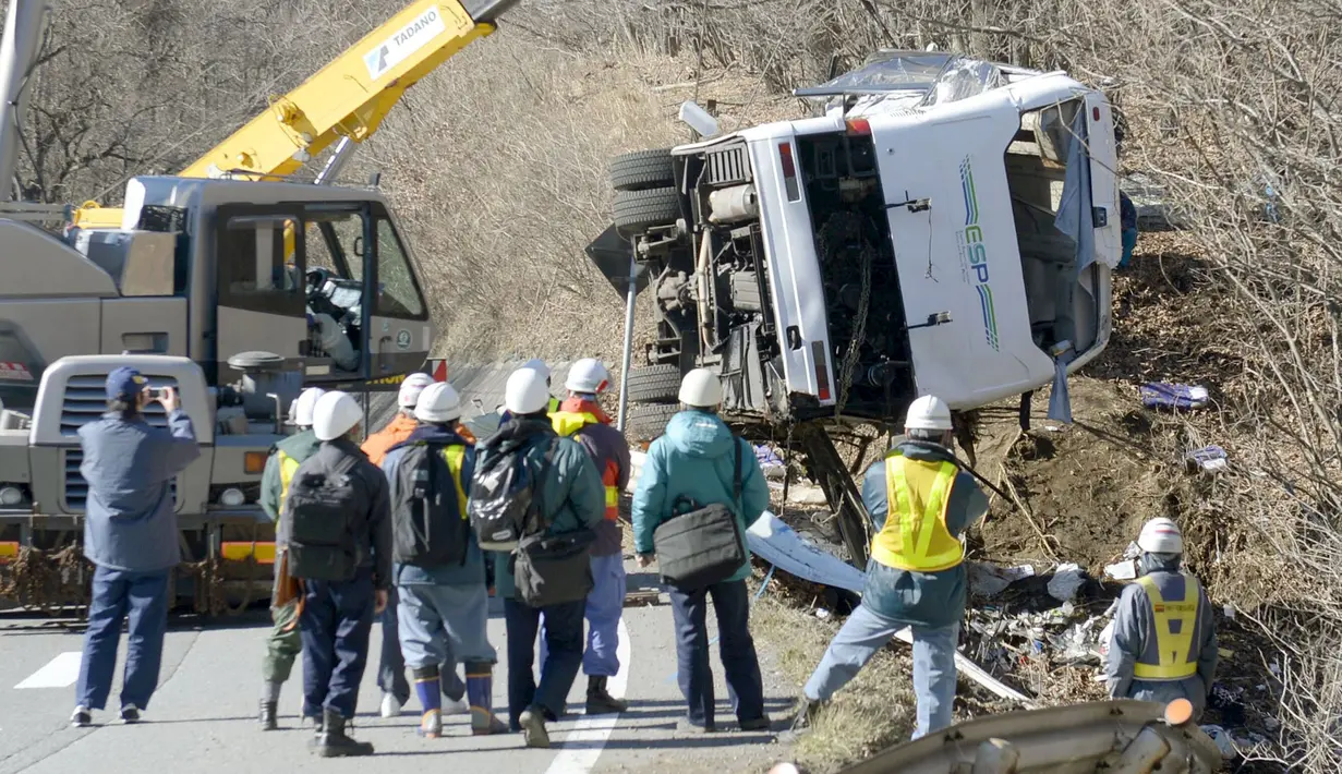Bangkai bus yang tergelincir diangkat menggunakan alat berat di Karuizawa, prefektur Nagano, Jepang, Jumat (15/1). Bus yang membawa pengunjung resor ski tersebut tergelincir dan menewaskan 14 orang serta melukai 27 lainnya. (REUTERS/Kyodo)
