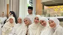 Ryana Dea kenakan dress putih panjang dengan vest jaring-jaring saat hadiri pernikahan Irish Bella. Dipadukan dengan hijab segitiga dengan clutch berwarna beige [@ryana_dea]