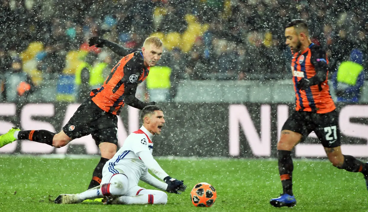 Bek Shakhtar Donetsk, Serhiy Kryvtsov (kiri) dan gelandang Olympique Lyon Houssem Aouar (tngah) berebut bola saat bermain pada penyisihan Grup F Liga Champions di Stadion NSK Olimpiyskyi, Kiev, Ukraina, Rabu (12/12). (SERGEI SUPINSKY/AFP)