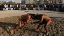 Pegulat Pakistan bertarung dalam kompetisi gulat Greco-Roman mingguan di Dubai (16/3). Gulat Greco-Roman dianggap sebagai turunan murni dari gulat Yunani dan Romawi kuno. (AFP Photo/Karim Sahib)