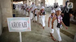 Murid TK jalan berbaris saat mengikuti edukasi manasik haji anak di Masjid At-Tin, Jakarta, Selasa (28/2/2023). Manasik haji yang diikuti puluhan murid TK se-Kecamatan Pasar Rebo tersebut dalam rangka mengenalkan rukun Islam kelima yakni ibadah haji serta tata cara melaksanakannya kepada anak sejak usia dini. (Liputan6.com/Faizal Fanani)