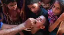 Seorang anak diberi vaksin kolera oleh sukarelawan Bangladesh di kamp pengungsi Thankhali di distrik Ukhia (10/10). Di tengah kekhawatiran wabah, PBB memberikan vaksinasi kolera untuk hampir satu juta orang Rohingya. (AFP Photo/Indranil Mukherjee)