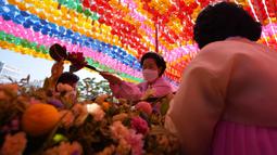 Seorang umat Buddha menuangkan air ke patung Buddha saat upacara merayakan ulang tahun Buddha di Kuil Jogye, Seoul, Korea Selatan, Rabu (19/5/2021). Umat Buddha mengunjungi kuil di seluruh negeri untuk merayakannya ulang tahun Sang Buddha. (AP Photo/Lee Jin-man)