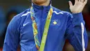 Atlet Kosovo Majlinda melambaikan tangan setelah meraih medali emas pada cabang judo putri di atas podium Olimpiade 2016, Minggu (7/8). Kelmendi yang merupakan peringkat dua di kelas 52kg mengalahkan Odette Giuffrida asal Italia. (Toshifumi Kitamura/AFP)