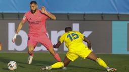 Striker Real Madrid, Karim Benzema, berusaha melewati pemain Cadiz, Carlos Akapo, pada laga Liga Spanyol di Stadion Alfredo Di Stefano, Minggu (18/10/2020). Real Madrid takluk dengan skor 1-0. (AP/Bernat Armangue))muh