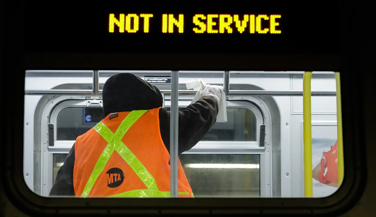 Pekerja otoritas transportasi kota New York bersiap membersihkan gerbong kereta bawah tanah dengan disinfektan di stasiun Coney Island di Brooklyn, Rabu (6/5/2020). Sistem kereta bawah tanah New York dimatikan sementara untuk dibersihkan guna menghentikan penyebaran Covid-19. (AP/Frank Franklin II)